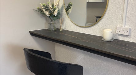 Sophisticated vanity area at Glossy Lox, Hull, England, GB featuring floral decor and a sleek mirror.