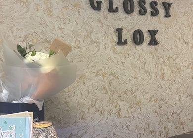Entrance of Glossy Lox in Hull, England, GB with elegant decor and floral display.