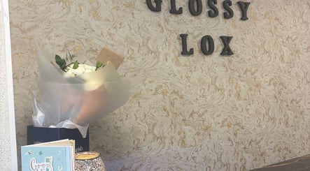 Entrance of Glossy Lox in Hull, England, GB with elegant decor and floral display.