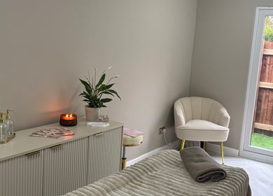 Relaxing treatment room at Alora SkinSpecialist, Birmingham, England, GB, featuring cozy chair and ambient lighting.