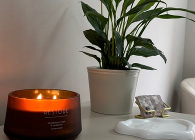 Tranquil setting at Alora SkinSpecialist, Birmingham, England, GB with a candle and lush plant.