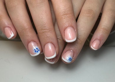Elegant French manicure with blue floral design at Molly’s Nail Club, Birmingham, England, GB.