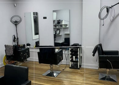 Sala elegante en Who Studio, Ñuñoa, Región Metropolitana, CL con espejos y sillas de peluquería.