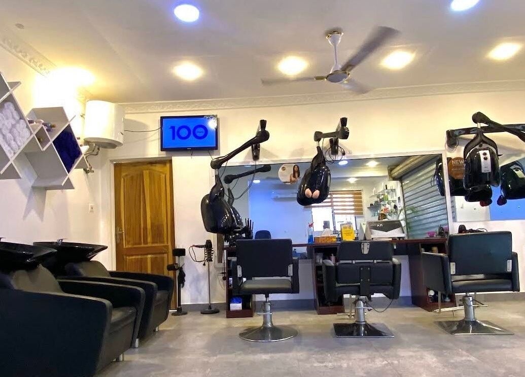 Interior of Charisma Salon and Spa in Adenta Municipality with styling chairs and hairdryers.