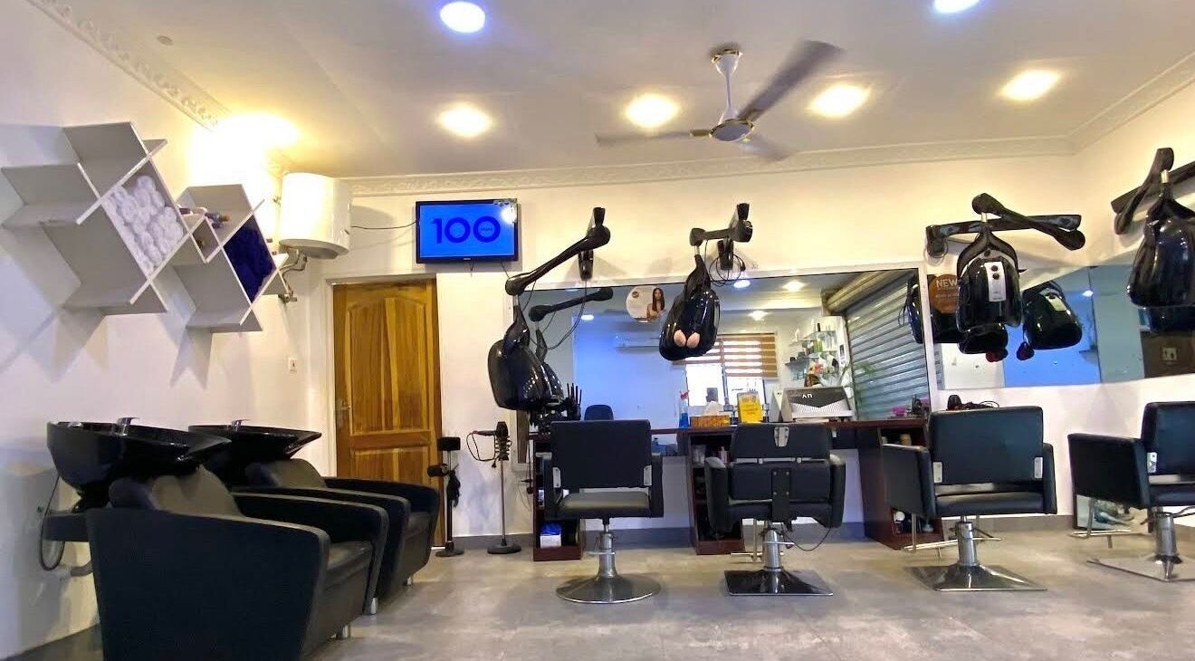 Interior of Charisma Salon and Spa in Adenta Municipality with styling chairs and hairdryers.