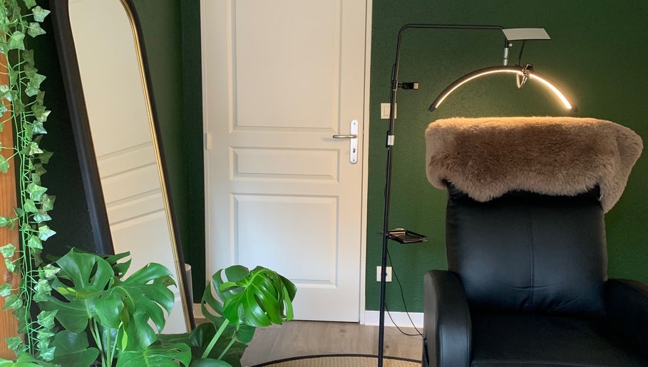 Coin détente chez Fanmcil à Rixheim, Grand Est, FR, avec fauteuil noir et plantes vertes.