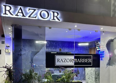 Entrada iluminada de Razor Barber en Pachuca De Soto, Hidalgo, MX, mostrando su moderna estética.