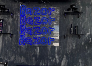 Pared con neón azul de Razor en Pachuca De Soto, Hidalgo, MX, mostrando estantes de productos de belleza.