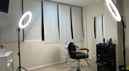 Estudio moderno de Zantinnobarberstudio en Mendoza, Mendoza, AR con silla y luminarias elegantes.