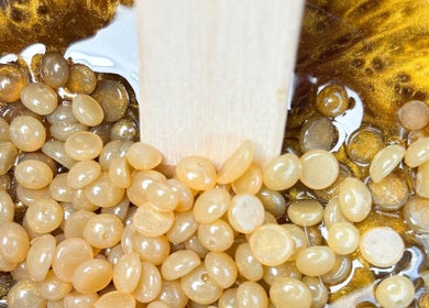 Perles de cire dorée prêtes pour une séance à Escapade Beauté, Vivonne, Nouvelle-aquitaine, FR.