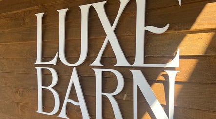Elegant 'Luxe Barn' sign on wood wall at Meg Eliot Hair, Clevedon, England, GB.