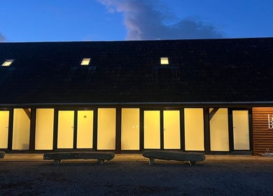 Evening view of Meg Eliot Hair, Clevedon, England, GB, showcasing illuminated modern architecture.
