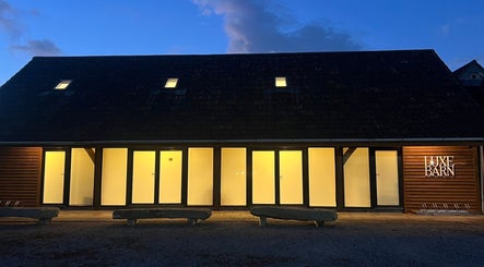 Evening view of Meg Eliot Hair, Clevedon, England, GB, showcasing illuminated modern architecture.