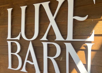 Luxe Barn sign on wood wall at Meg Eliot Hair in Clevedon, England, GB.