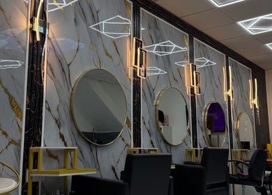 Elegant salon interior with round mirrors and modern lighting at Rim’s Hairdressing, Sheffield, England, GB.