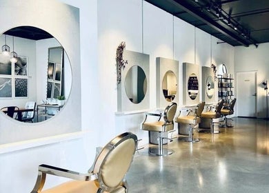 Chic interior of Hair by Sarah, Auckland, NZ, featuring stylish mirrors and chairs.