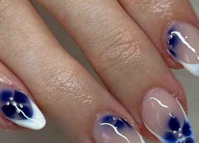 Elegant blue floral nail art at Beautyby_evie_x in Wisbech, England, GB.
