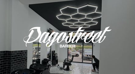 Interno moderno di Dagostreet Barber a Mombretto, Lombardia, IT con sedie eleganti e illuminazione artistica.