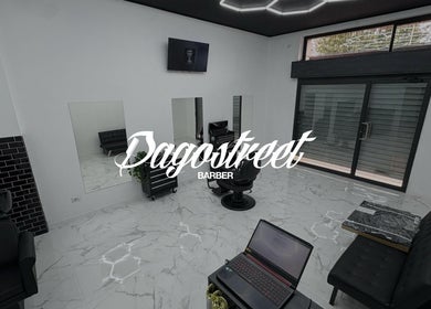 Interno moderno di Dagostreet Barber a Mombretto, Lombardia, IT, con sedie nere e pavimenti in marmo.