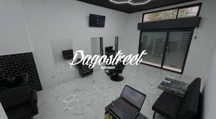 Interno moderno di Dagostreet Barber a Mombretto, Lombardia, IT, con sedie nere e pavimenti in marmo.