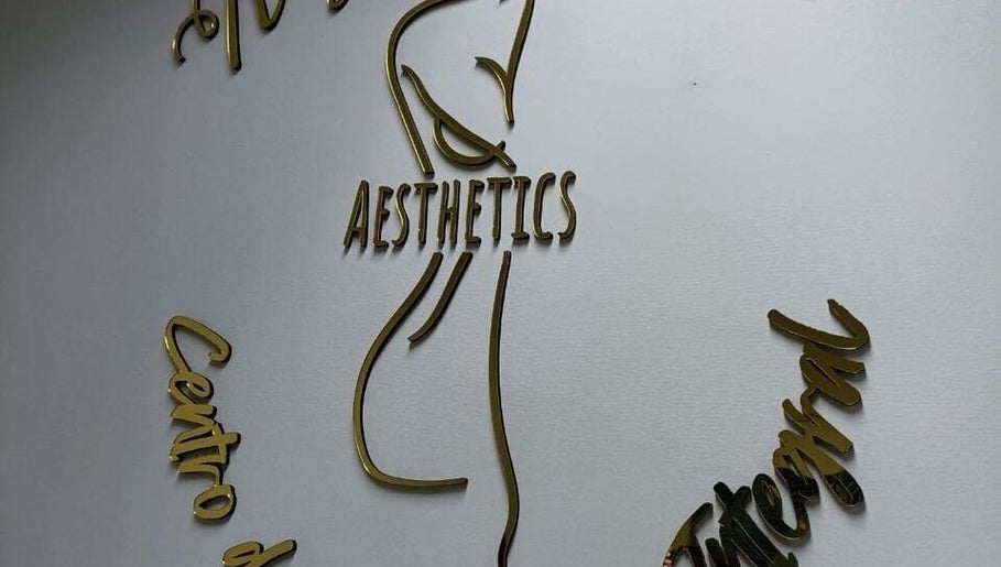 Logo dorado de Estética Rayen Anais Aesthetics en pared blanca en Santiago, Región Metropolitana, CL.