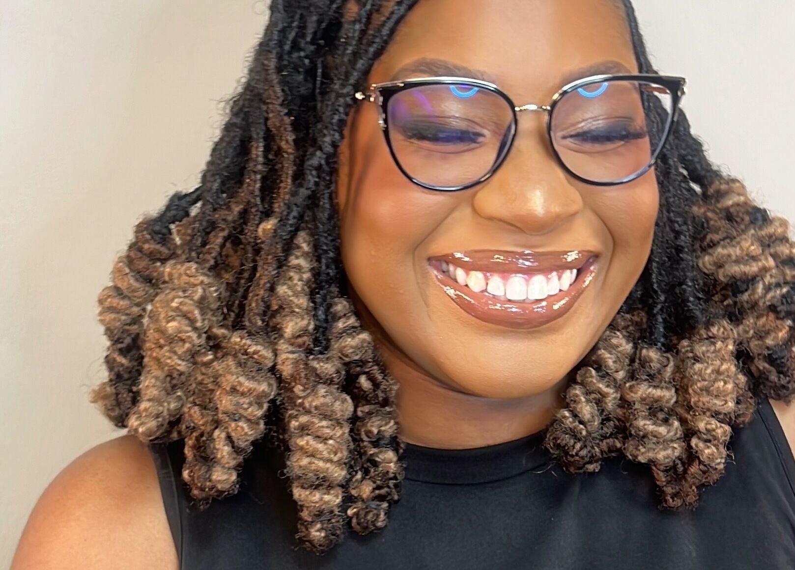 Smiling woman with curly hair at The Island Beauty, Arima, Arima Borough Corporation, TT.