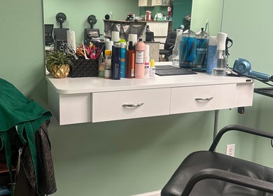 The Style Lab Beauty Salon in Bentleyville, PA features a styling station with products and a mirror.