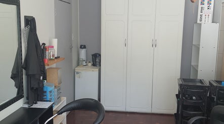 Cozy interior of Glam Ink Hair salon in Benoni, Gauteng, ZA with mirrors and storage units.