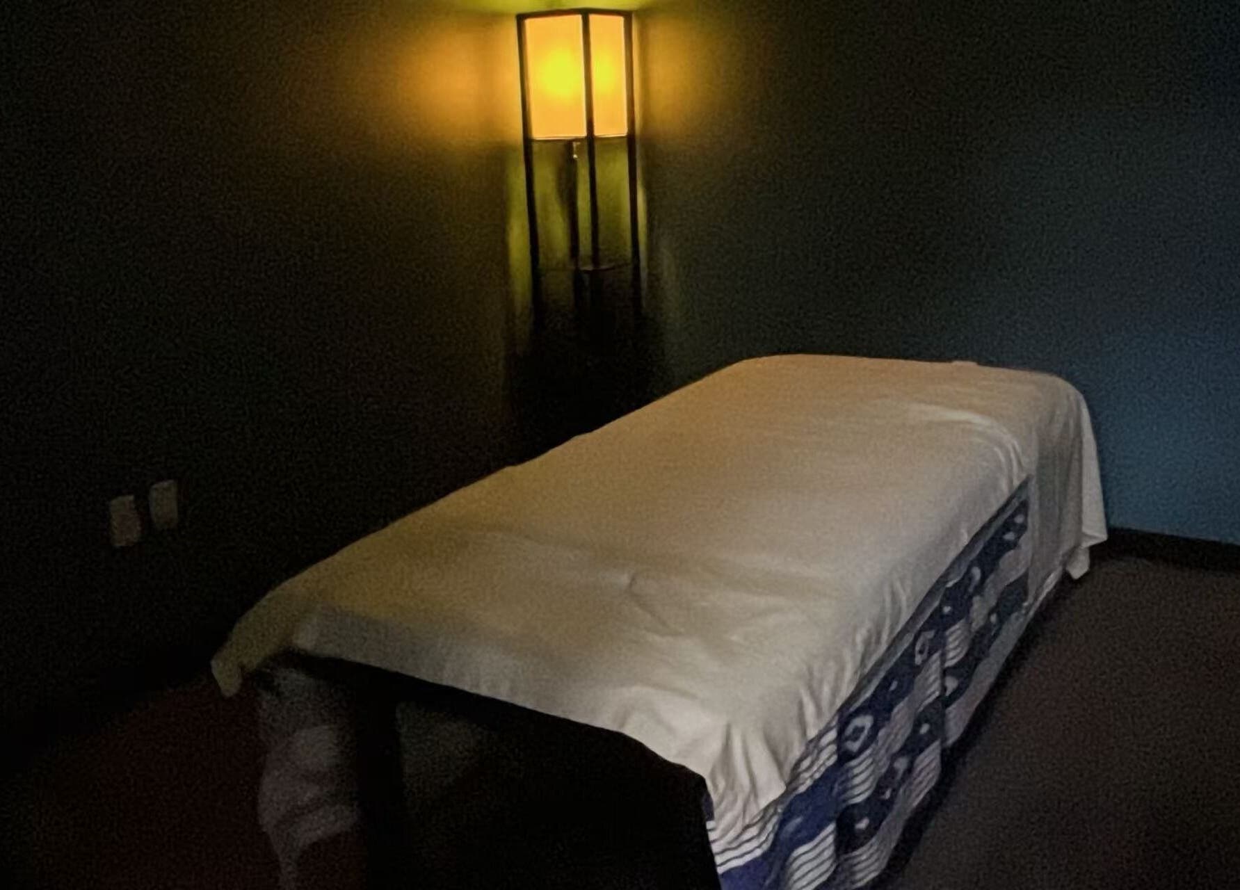 Cozy massage room at Lotus Massage Spa, Chesterfield, Michigan, US, softly lit for relaxation.
