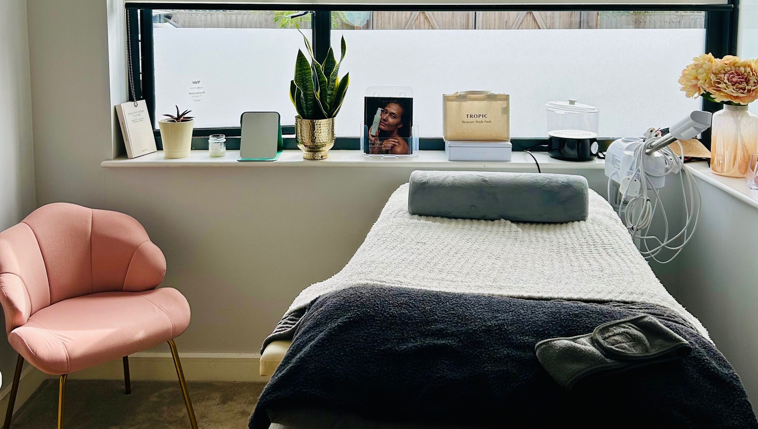 Cozy treatment room at VF Skincare & Facials, Winchester, England, GB with a plush pink chair and treatment bed.