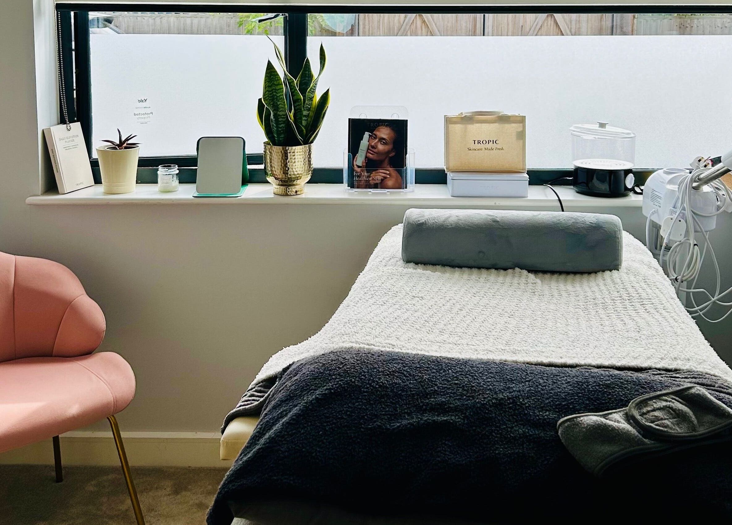 Cozy treatment room at VF Skincare & Facials, Winchester, England, GB with a plush pink chair and treatment bed.