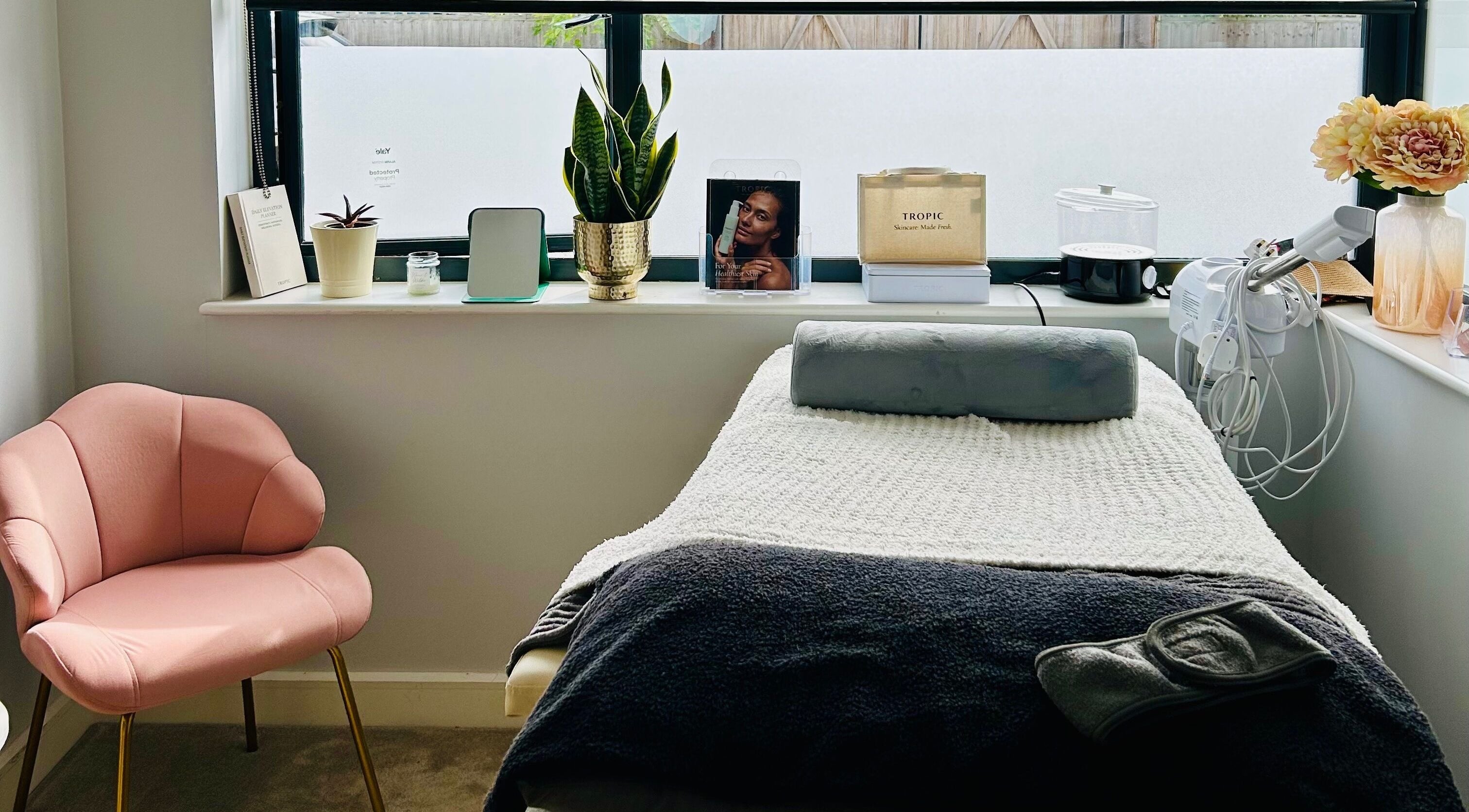 Cozy treatment room at VF Skincare & Facials, Winchester, England, GB with a plush pink chair and treatment bed.