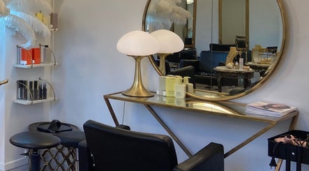 Intérieur chic du salon Maxime à Paris, Île-de-France avec mobilier élégant et produits de beauté exposés.