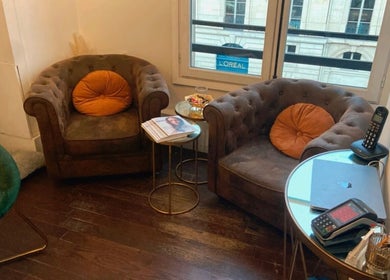 Coin salon élégant chez Maxime, Paris, Île-de-France, FR, avec fauteuils accueillants et table moderne.