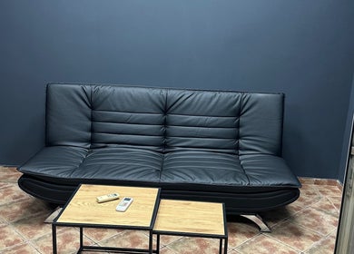 Modern black leather sofa in Berbernica Trisa, Beograd, batajnica, RS welcoming guests.