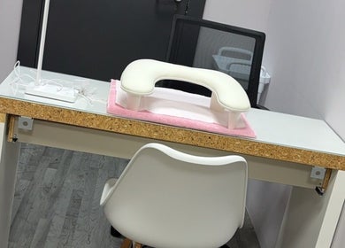 Modern nail station at NailedbyColleen in Belfast, Northern Ireland, GB features sleek white design and comfort chair.