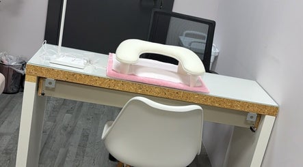 Modern nail station at NailedbyColleen in Belfast, Northern Ireland, GB features sleek white design and comfort chair.