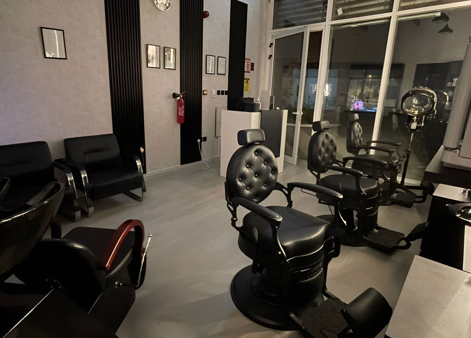 Modern interior of Sharp Touch Gents Salon in Sharjah, إمارة الشارقةّ, AE, featuring stylish black chairs.