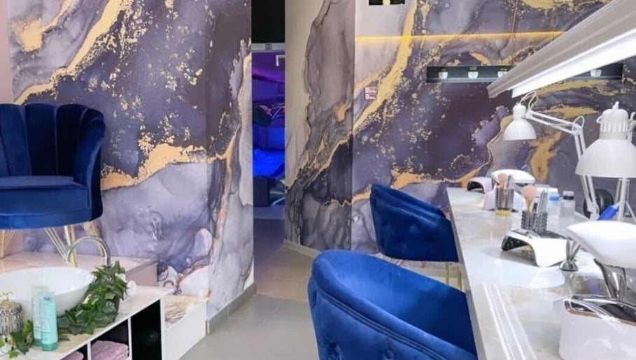 Luxurious beauty station at Studio Omega, Novi Sad, Vojvodina, RS featuring blue chairs and marble accents.