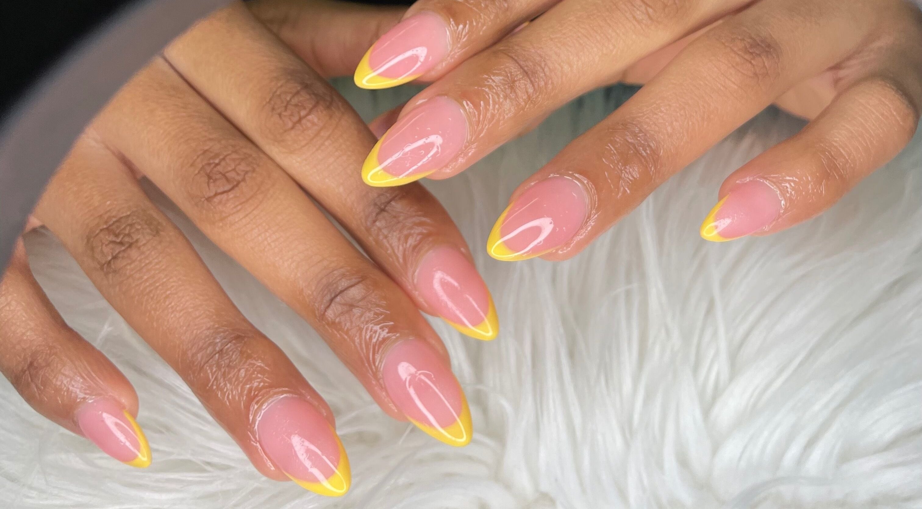 Bright yellow-tipped nails at Wino'S Nail Pub, Gaborone, Gaborone City, BW on a soft white surface.