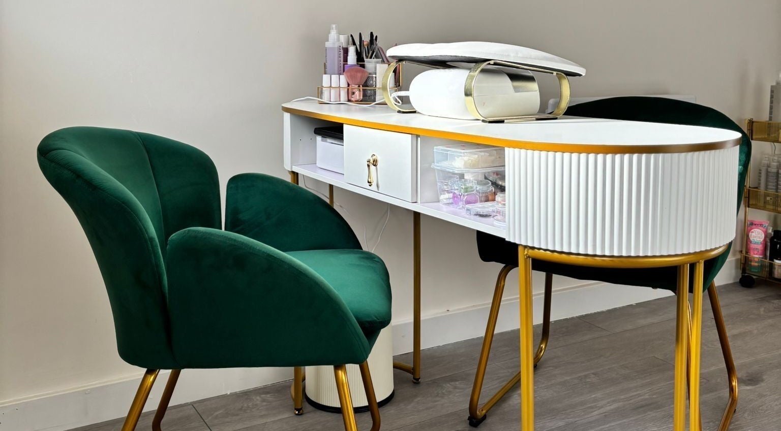 Sophisticated nail station at The Beauty Space by Katie Bancroft, Leicester, England, GB, with plush green chairs.