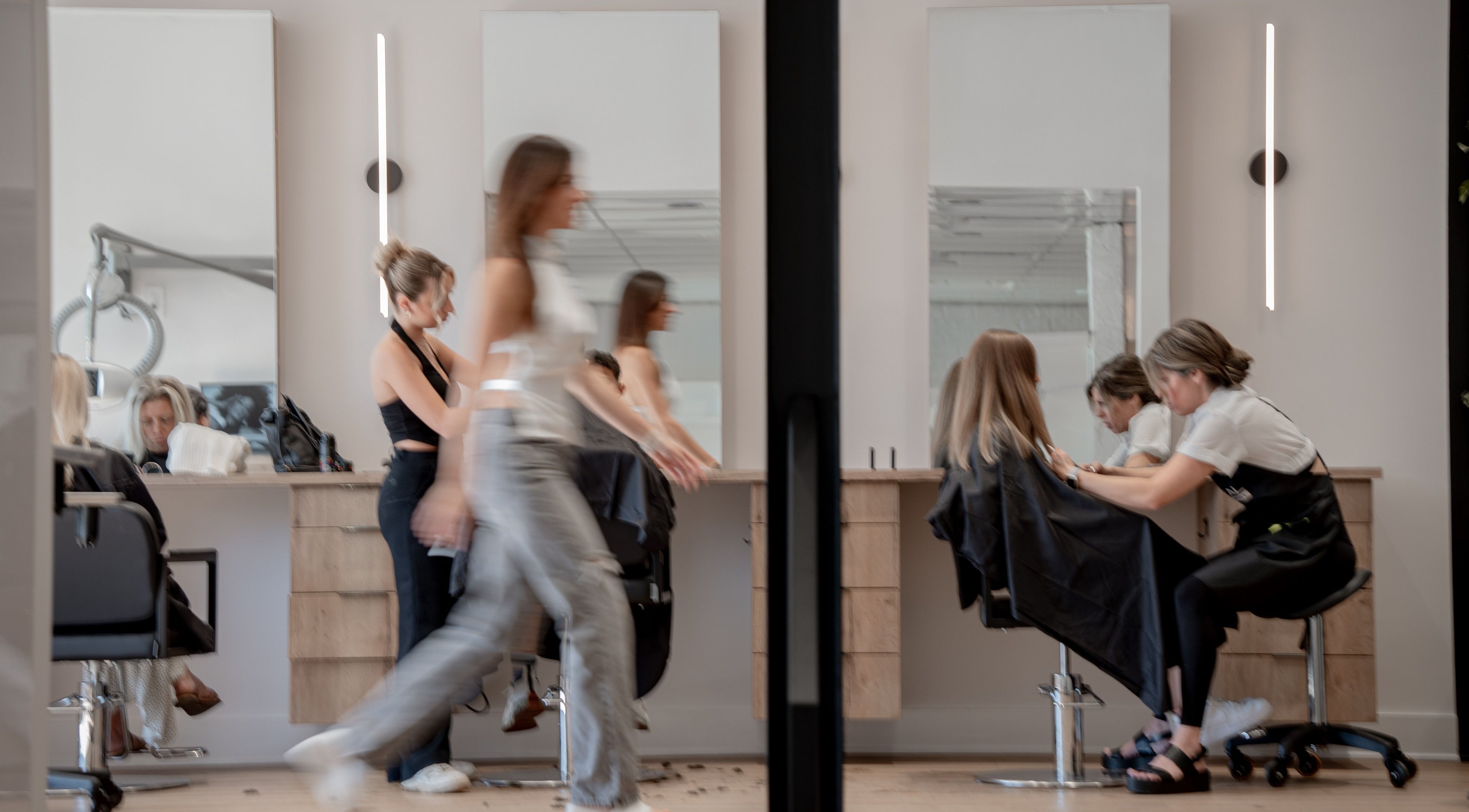 Salon moderne à La Suite Claudio, Saint-Jérôme, Québec, CA, avec clients et stylistes professionnels.