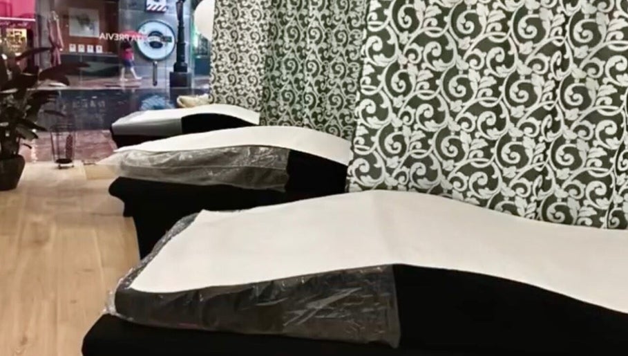 Zona de descanso en Jasmin Beauty Studio, Oviedo, ES, con sillas elegantes y decoración floral.