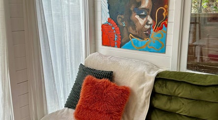 Relaxing corner with vibrant art and cushions at Pinch Nails, London, England, GB.