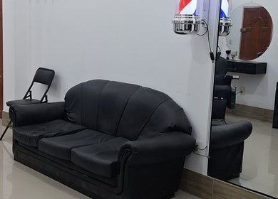 Sala de espera cómoda en NIFC, Viacha, Departamento De La Paz, BO, con sofá negro y espejo.