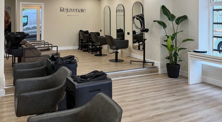 Modern interior of Rejuvenate@45 in Stockport, England, showcasing stylish chairs and mirrors.