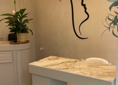 Elegant reception area at Haus of Nails, Birmingham, England, GB with minimalist decor and lush green plants.