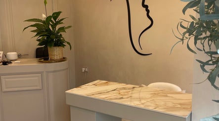 Elegant reception area at Haus of Nails, Birmingham, England, GB with minimalist decor and lush green plants.