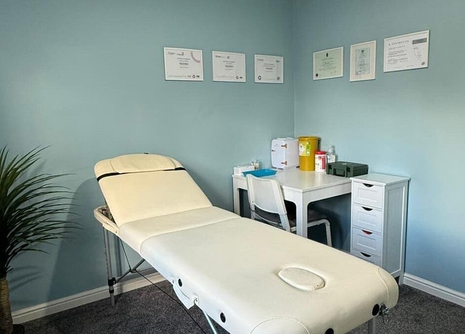Peaceful treatment room at Key Aesthetics, Swindon, England, GB, with a white therapy bed and certificates.