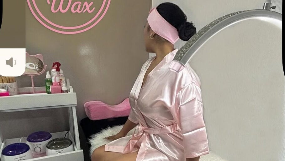Cliente relajándose en Pinky Wax, Ciudad De México, MX con bata rosa en elegante cabina de estética.